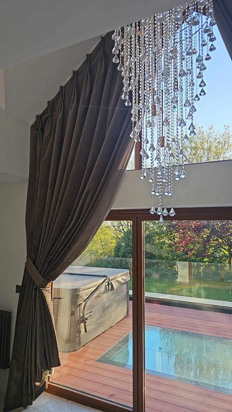 Tall gable-end glazing dressed with neutral curtains